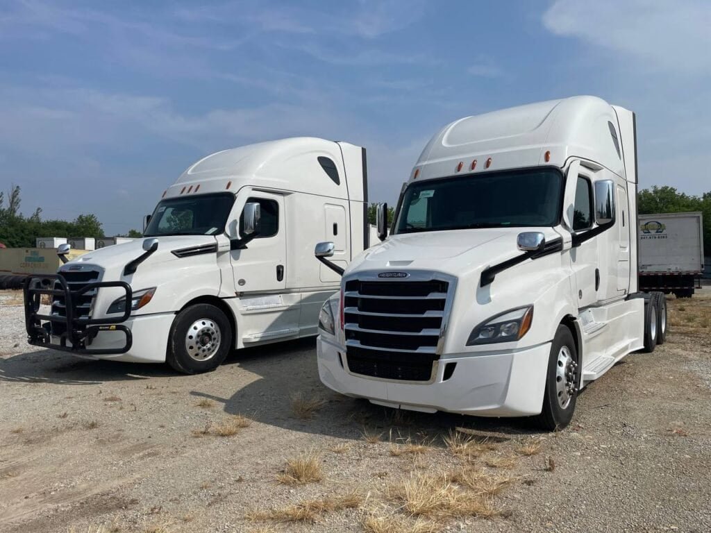 two white trucks in the parking lot